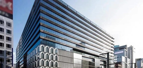 ガラス張りの外観が特徴的な大型の現代的オフィスビル